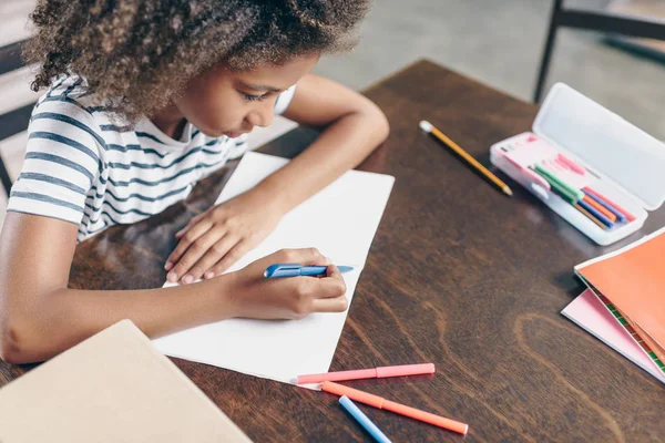 Little girl writing in notebook — Stock Photo