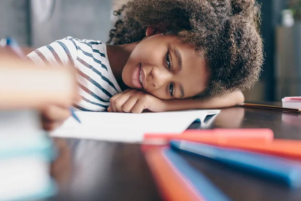 Petite fille écrivant dans un carnet — Photo de stock