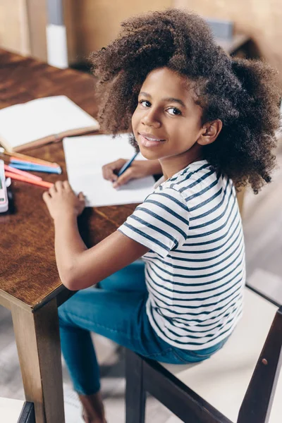 Niña con pluma y cuaderno - foto de stock