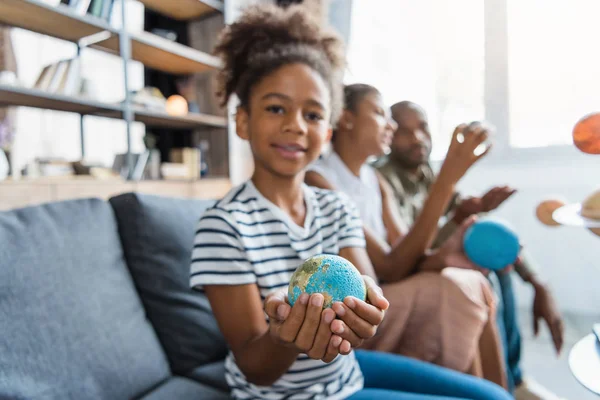 Petite fille avec figurine globe dans les mains — Photo de stock