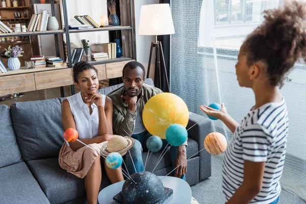 Girl telling parents about solar system — Stock Photo