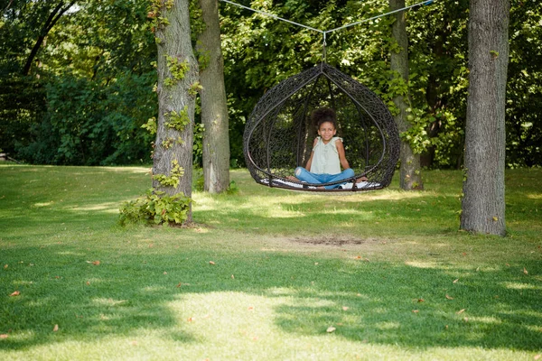 Kid swinging on swing in park — Stock Photo