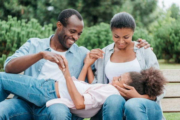 African american family resting on bench — Stock Photo