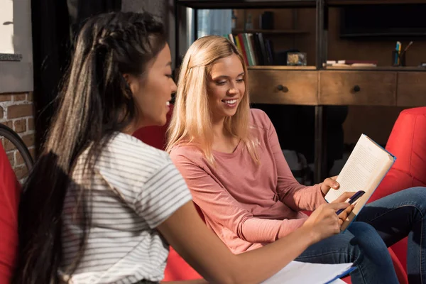 Multiethnic girls studying with book — Stock Photo