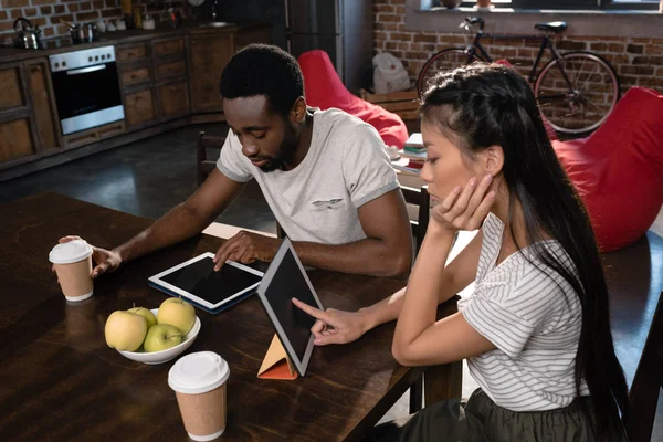 Pareja usando tabletas en la cocina - foto de stock