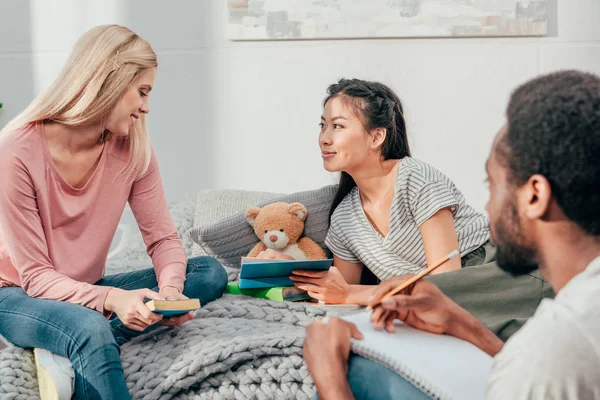 Giovani studenti che fanno i compiti insieme — Foto stock