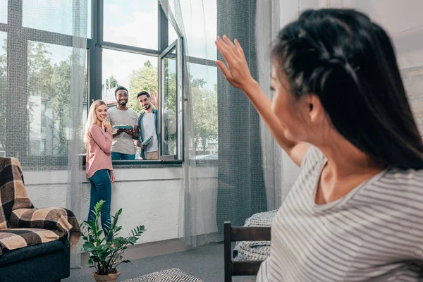 Jovem mulher acenando para amigos — Fotografia de Stock