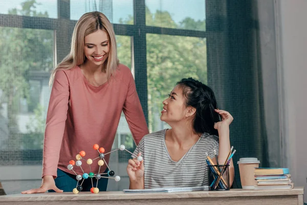 Mujeres que estudian con el modelo químico - foto de stock