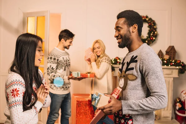 Casais multiétnicos trocando presentes de Natal — Fotografia de Stock