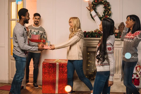 Amigos multiculturales que intercambian regalos de Navidad - foto de stock