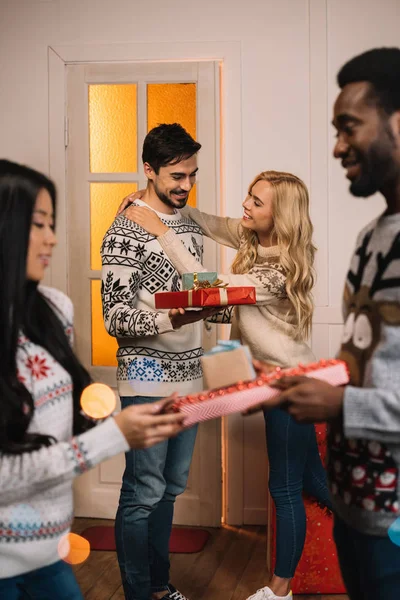 Multiethnic couples exchanging christmas gifts — Stock Photo
