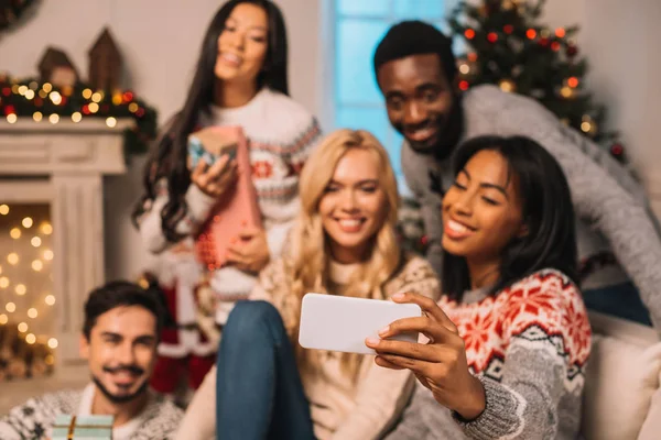 Amigos multiétnicos tomando selfie en Navidad - foto de stock
