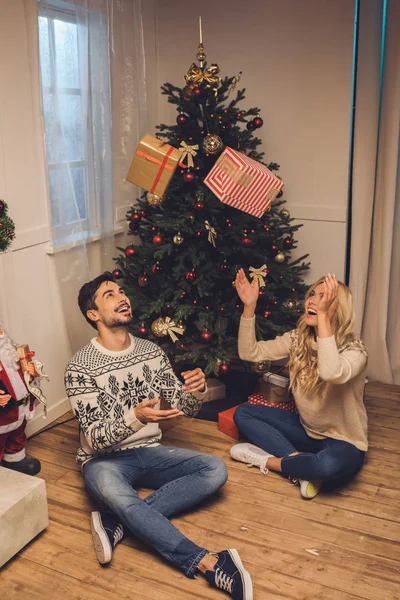 Happy couple with gifts at home on christmas — Stock Photo