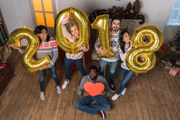 Multicultural friends with balloons and paper heart — Stock Photo