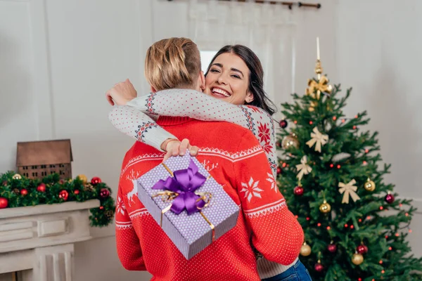 Mujer abrazando a su novio en Navidad - foto de stock