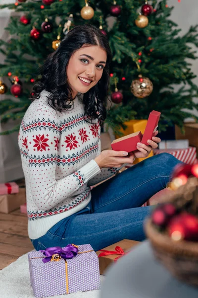 Жінка розпаковує різдвяний подарунок — стокове фото