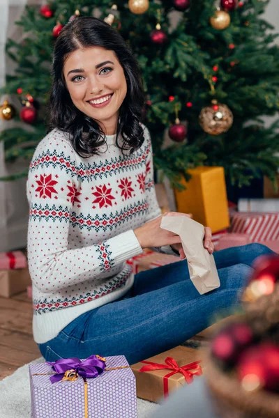 Frau packt Weihnachtsgeschenk aus — Stockfoto