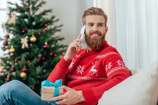 Mann mit Weihnachtsgeschenk telefoniert — Stockfoto