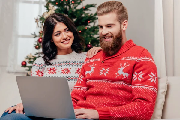 Счастливая пара с помощью ноутбука на Рождество — стоковое фото