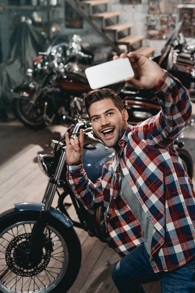 Hombre tomando selfie con moto - foto de stock