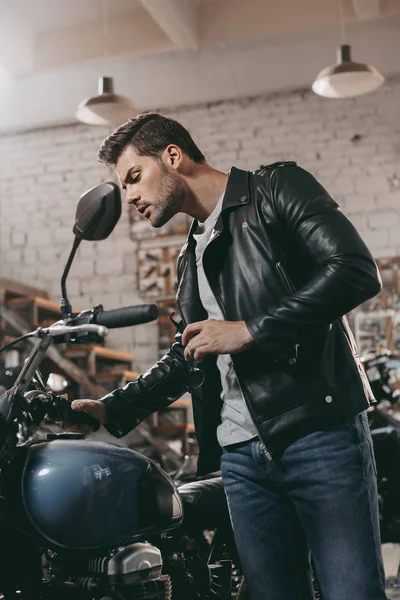 Motociclista em jaqueta de couro com motocicleta — Fotografia de Stock