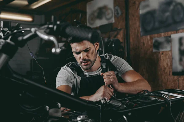 Mechanic repairing motorcycle — Stock Photo