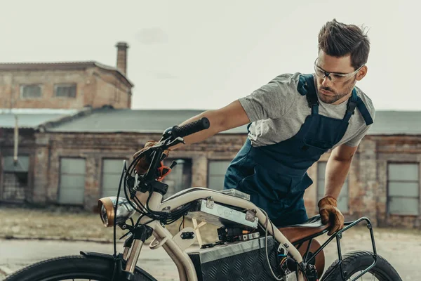 Mechanic in goggles repairing motorcycle — Stock Photo