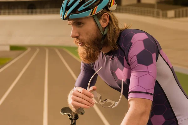 Вдумчивый велогонщик в шлеме — стоковое фото