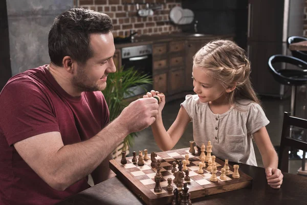 Vater und Tochter stoßen sich an Schachfiguren — Stockfoto