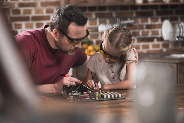 Père enseignant à sa fille à braser — Photo de stock