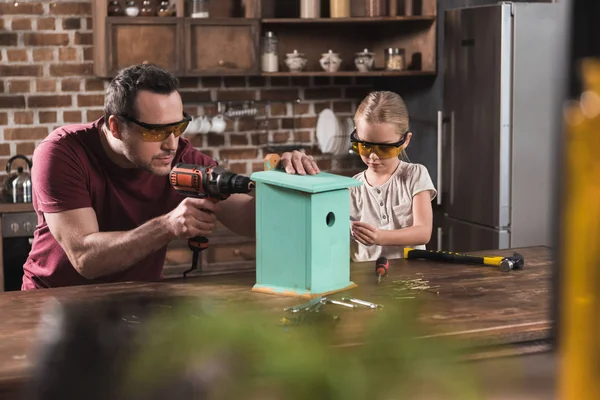 Daughter and father making birdhouse — Stock Photo