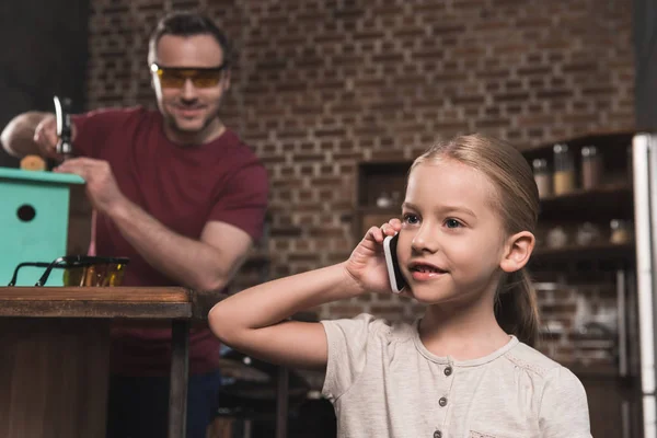 Hija hablando por teléfono inteligente - foto de stock