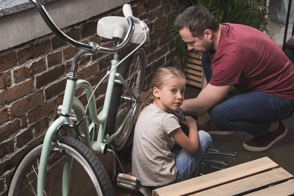 Pai e filha reparando bicicleta — Fotografia de Stock