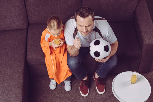 Hija y padre viendo juego de fútbol - foto de stock