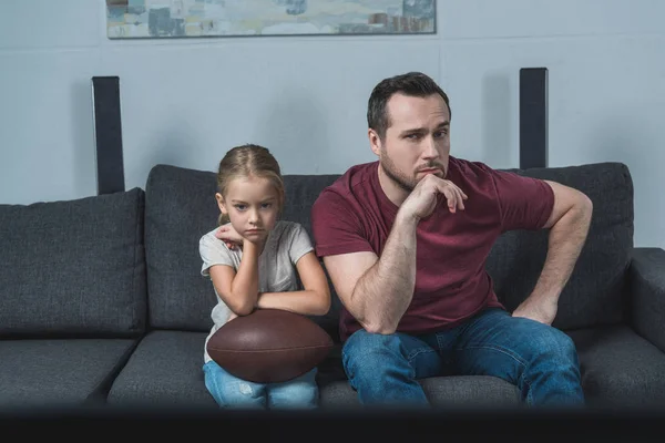 Father and daughter watching american football game — Stock Photo