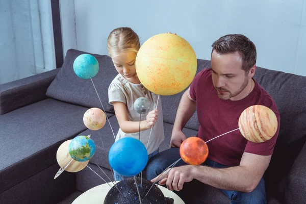 Отец показывает модель солнечной системы — стоковое фото