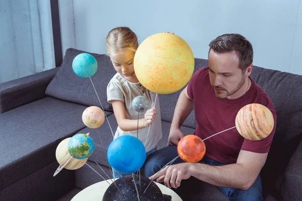 Father showing model of solar system — Stock Photo