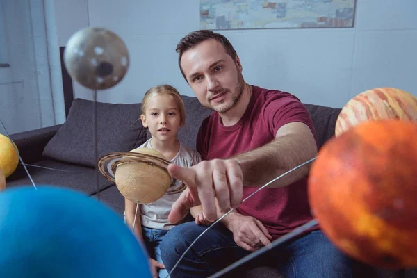 Father showing daughter a planet — Stock Photo