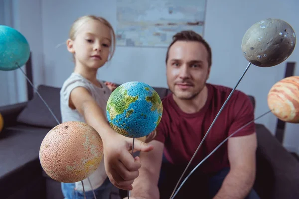 Daughter showing father model of Earth — Stock Photo