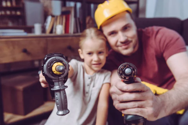 Pai e filha posando com brocas de brinquedo — Fotografia de Stock