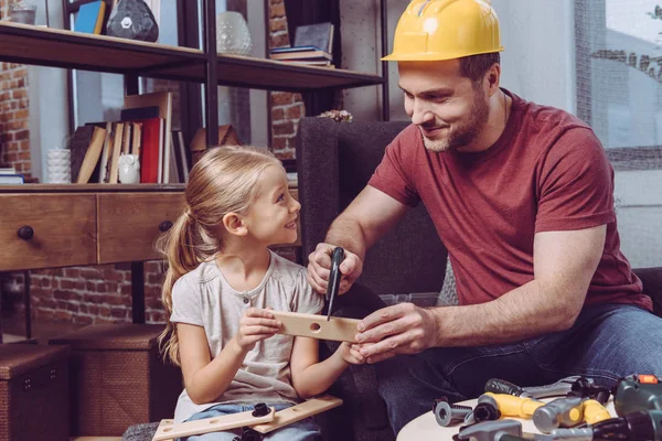 Padre e hija haciendo marco de madera - foto de stock