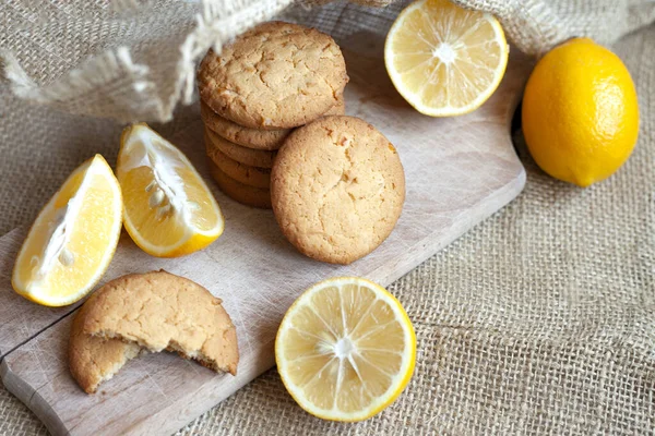 Lemon gingerbread cookies lie on a wooden board on a rustic table, still life of fresh biscuits with citrus, copy space — Stock Photo, Image