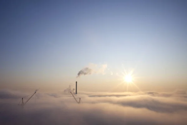 Густой туман над городом, фиолетовый солнечный рассвет над облаками, концепция загрязнения атмосферного дыма — стоковое фото