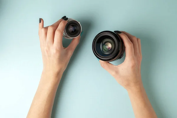 Ensemble de lentilles photo sur un fond coloré, la sélection et la comparaison de l'équipement photographique, les mains tiennent l'équipement photo — Photo