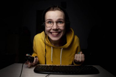 Kız oyuncu gece evde dizüstü bilgisayarda oturur, bir öğrenci oyun oynar, kaybeder ve kazanır.