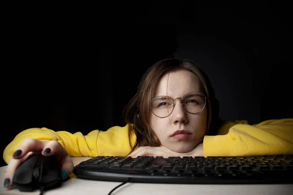 Menina gamer senta-se em um laptop à noite em casa, um estudante joga jogos, ela perde e ganha — Fotografia de Stock