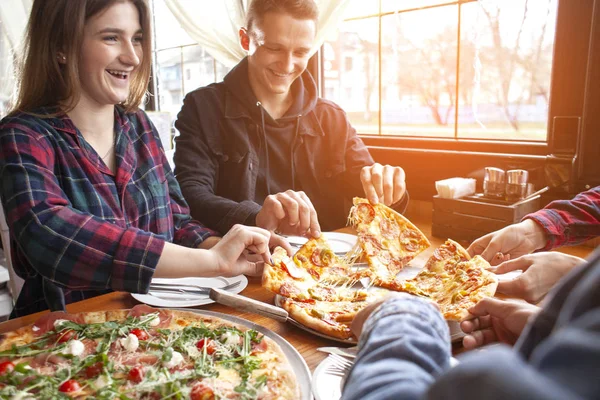 friends of classmates eat pizza in a pizzeria, students at lunch eat fast food