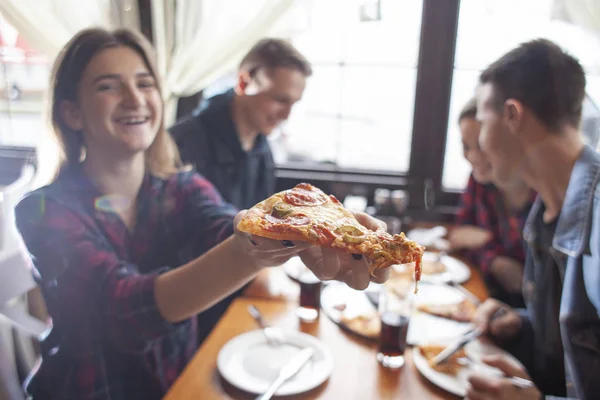 friends of classmates eat pizza in a pizzeria, students at lunch eat fast food