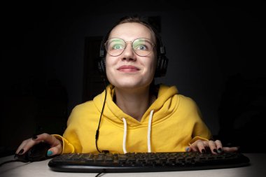 Kız oyuncu gece evde dizüstü bilgisayarda oturur, bir öğrenci oyun oynar, kaybeder ve kazanır.