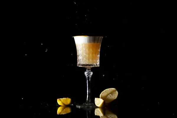 Классический янтарный коктейль с цитрусовыми и льдом на черном фоне — стоковое фото